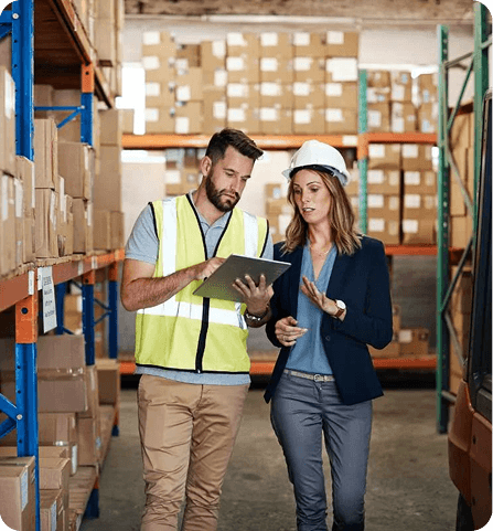 Warehouse and operations managers reviewing stock records together